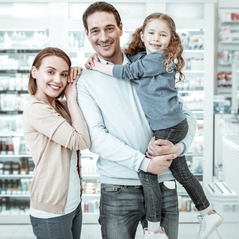 Padres con hijos en una farmacia.
