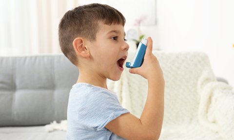 Niño asmático con un inhalador