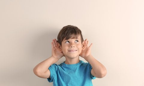 Niño con las manos en las orejas