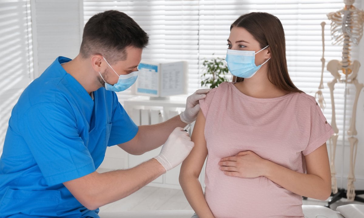 Mujer embarazada vacunándose contra la COVID
