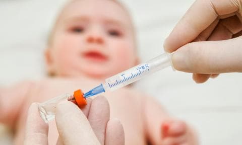 Doctor prepara vacuna para bebé