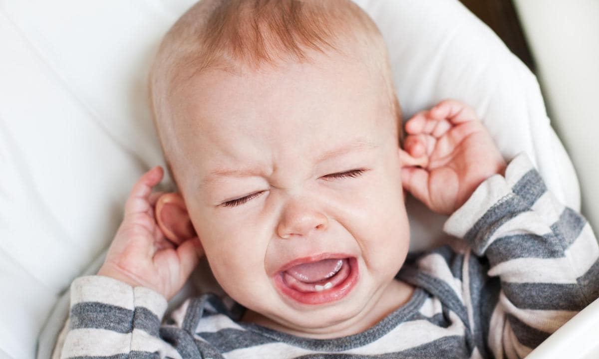 Bebé llorando tocándose las orejas