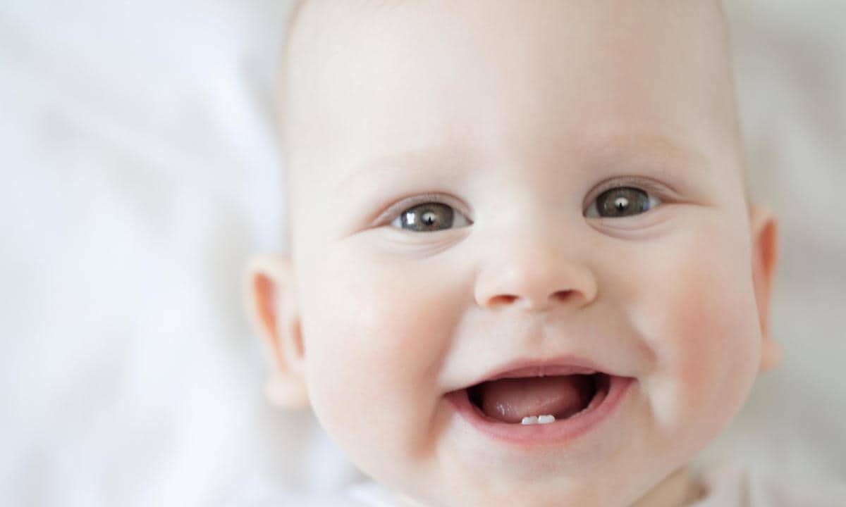 Bebé sonriendo con sus primeros dientes