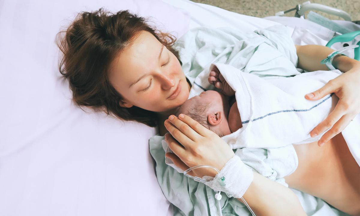 Mujer con su bebé después del parto en el hospital