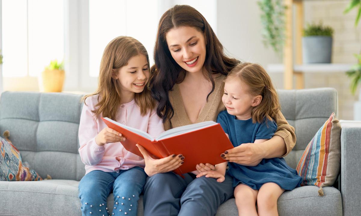 Madre con sus hijas leyendo libros