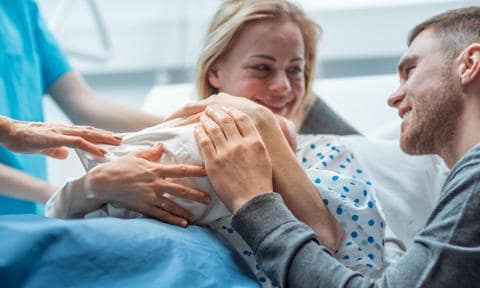 Pareja con bebé después del parto en el hospital