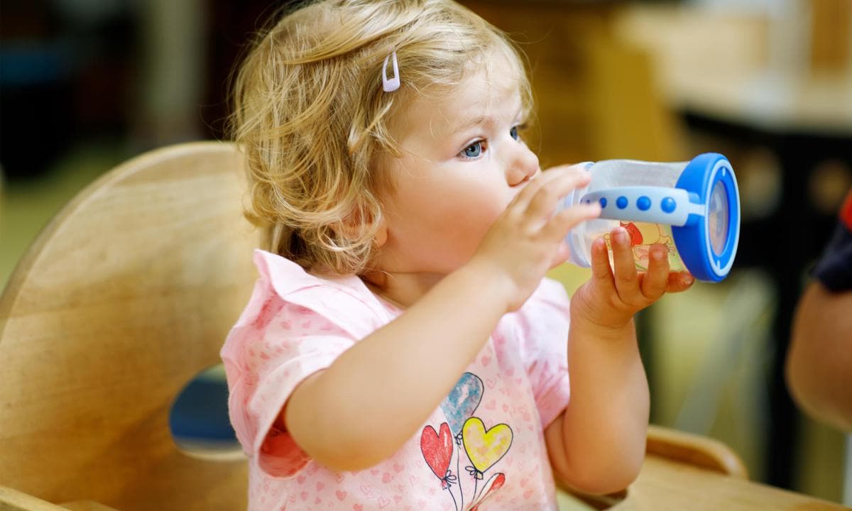 Bebé bebiendo agua en vasito de aprendizaje