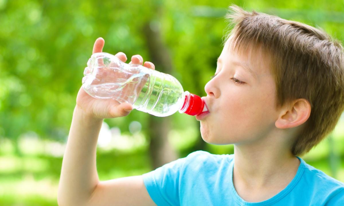 Niño bebiendo en botella de agua