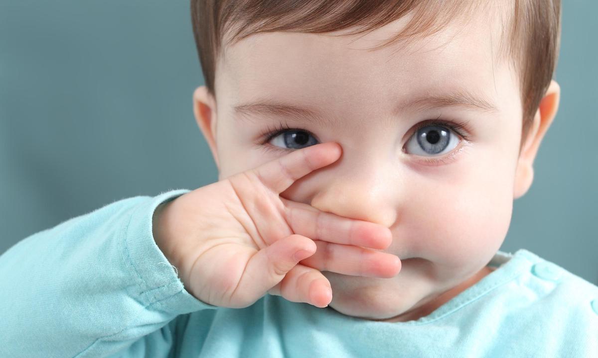 Niño con la mano en la nariz