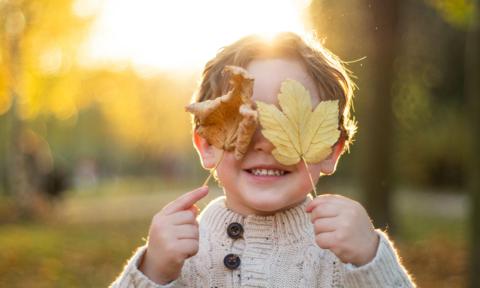 Niño con hojas de otoño