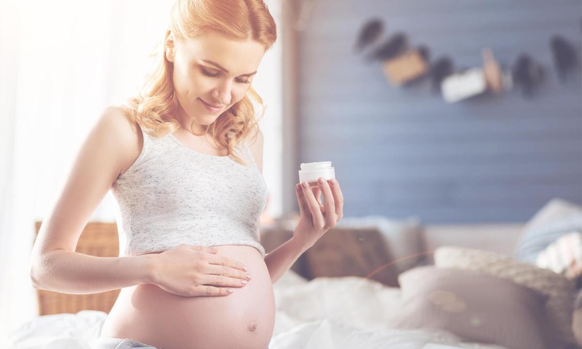 Mujer embarazada aplicándose cremas