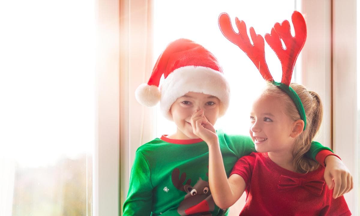 Niños vestidos con prendas y accesorios navideños