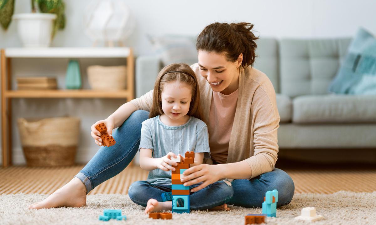 Madre e hija jugando en el suelo