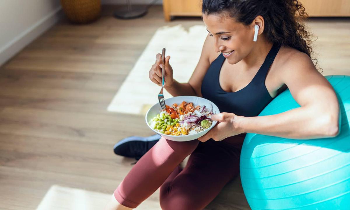 Mujer termina de hacer deporte y come comida saludable