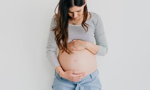 Microbiota y fertilidad. Mujer embarazada mirándose la tripa.