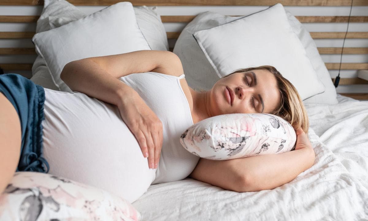 Mujer embarazada descansando en la cama