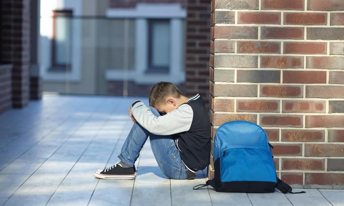 Niño llorando en el pasillo del colegio