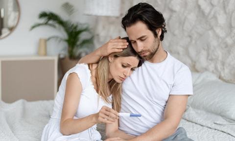 Pareja con problemas de infertilidad con test de embarazo