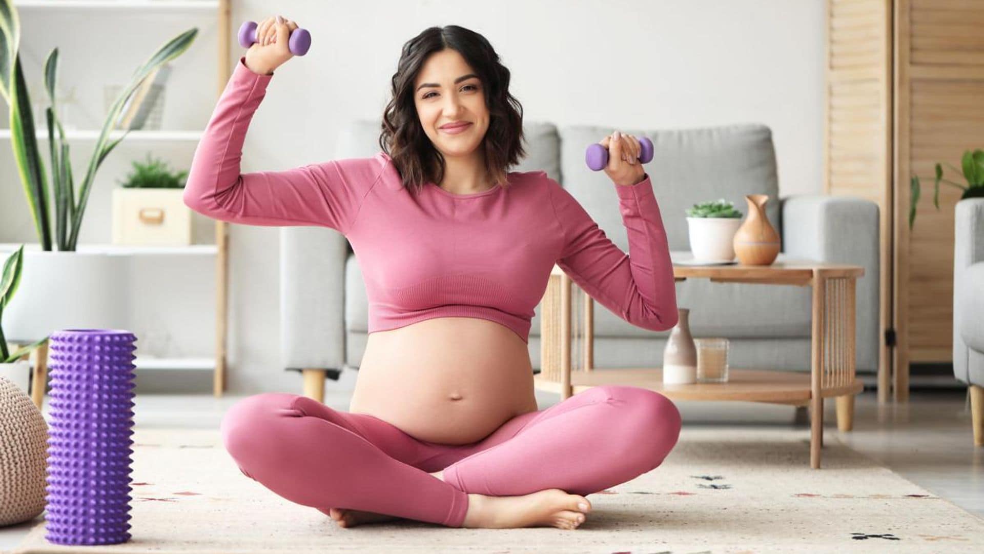 Embarazada con pesas mientras hace ejercicio