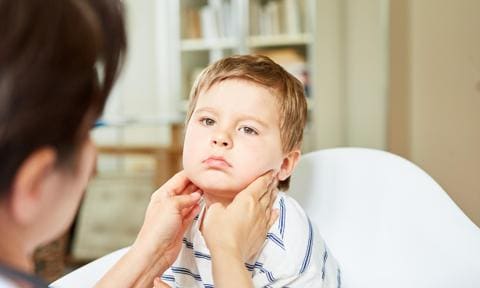 Doctor explorando el cuello de un niño