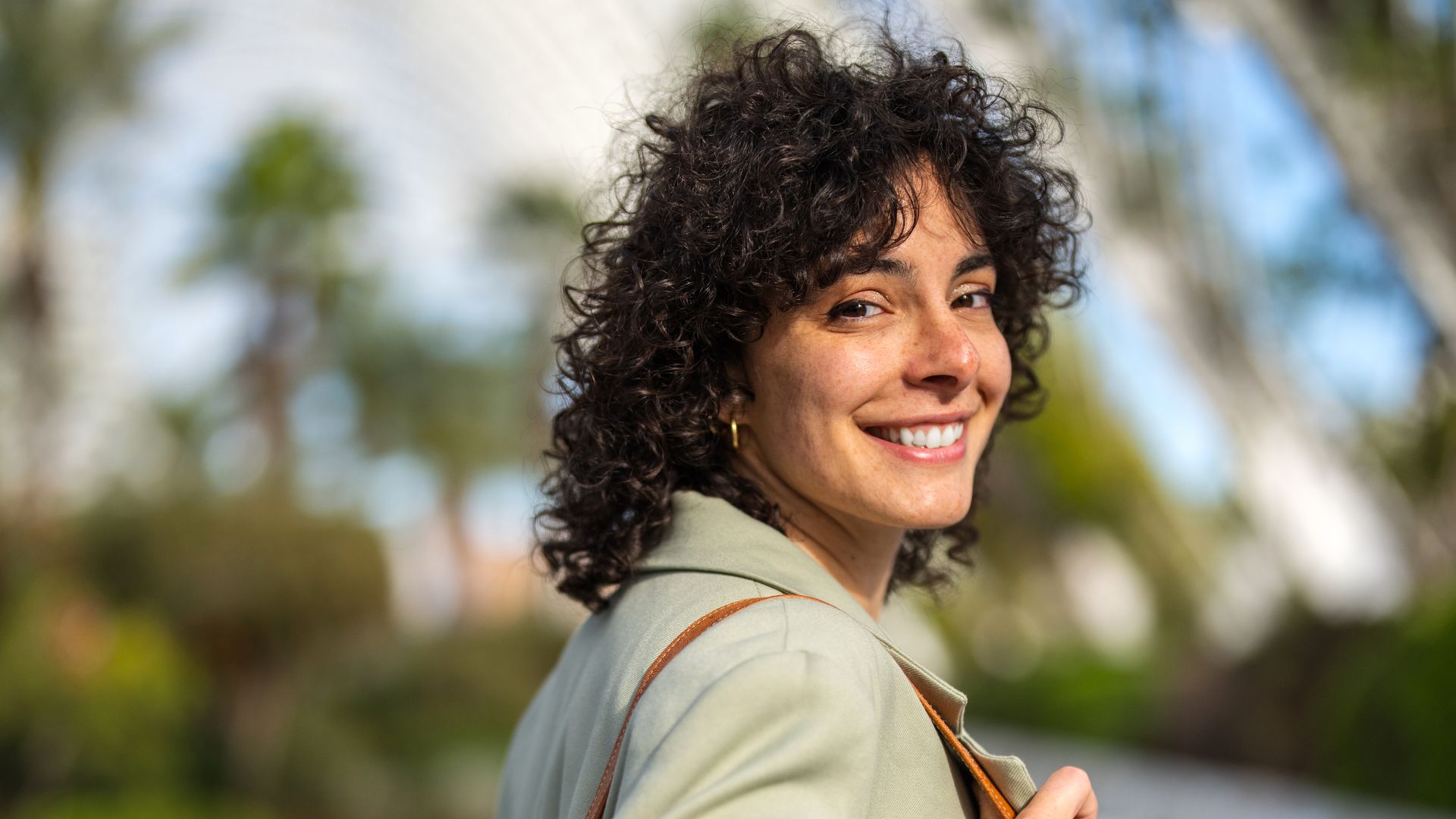 https://www.hola.com/us/horizon/landscape/0584edad8d11-hermosa-estudiante-sonriente-caminando-despuc3a9s-de-las-clases-mirando-a-la-c.jpg?im=Resize=(1200)