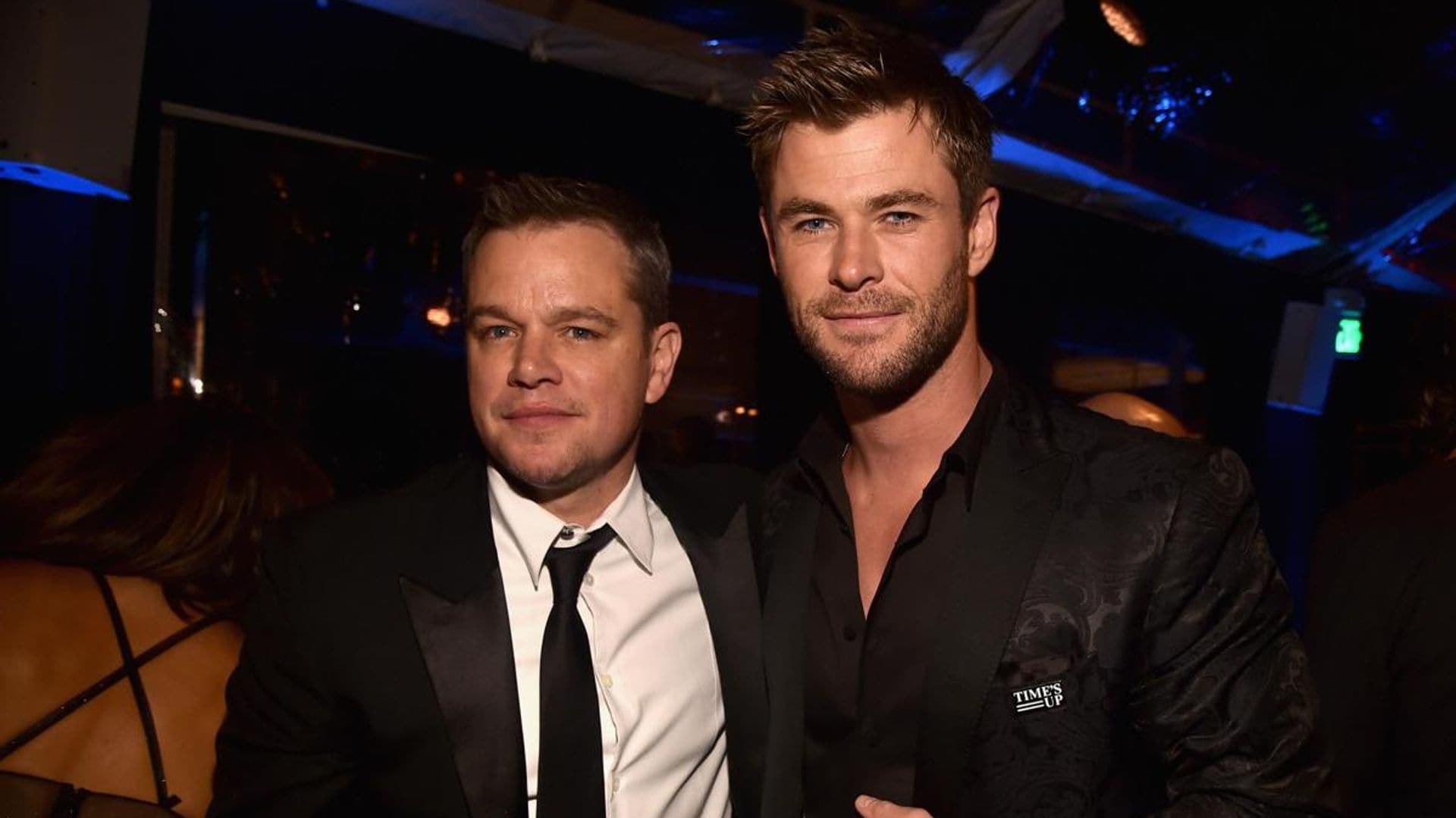 Matt Damon gets a tattoo while Chris Hemsworth holds his hand