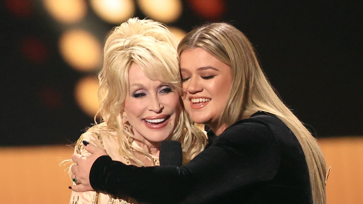 https://www.hola.com/us/horizon/landscape/1200/a9d644df1968-dolly-parton-and-kelly-clarkson-speak-onstage-during-at-the-academy-of-country-m.jpg