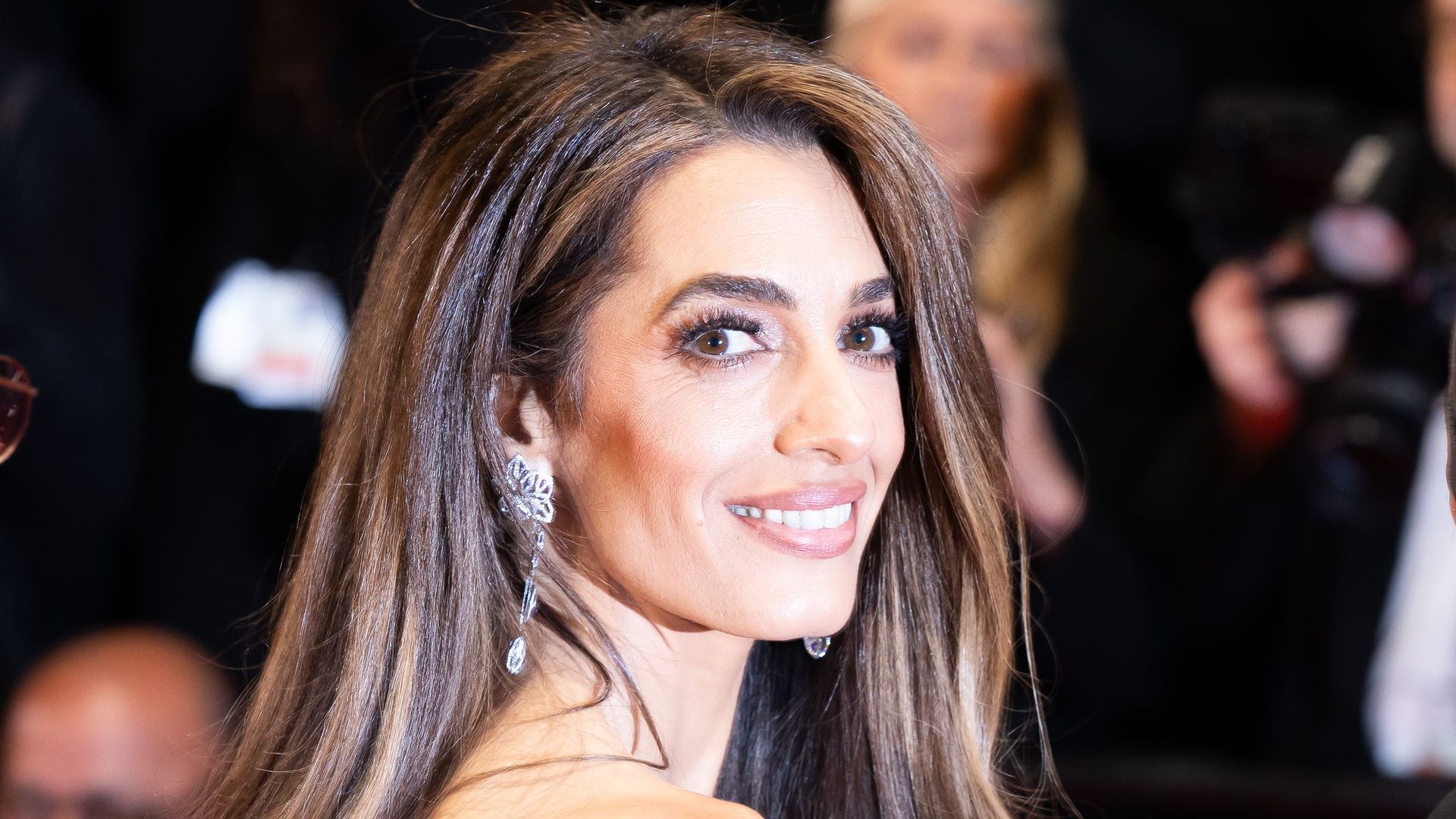 Amal Clooney has a bridal moment in slinky white dress with flowers in hand beside George in Lake Como