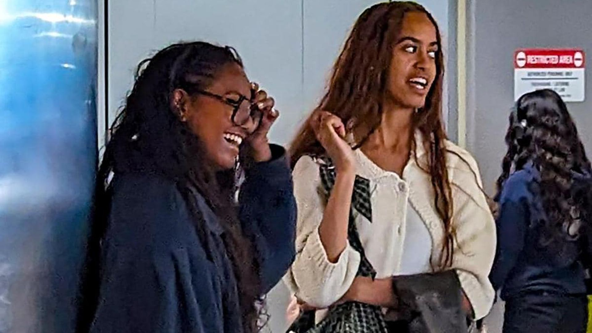 Malia and Sasha Obama laugh together at LAX