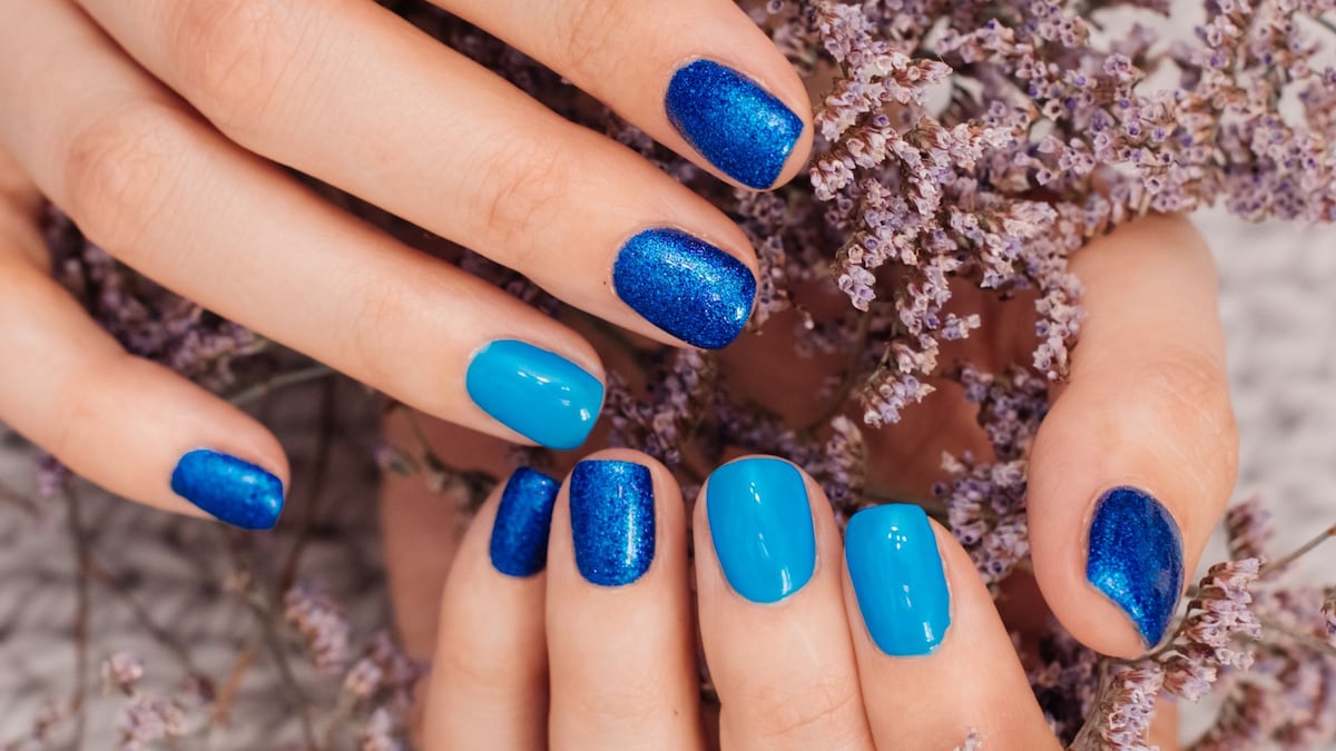 https://www.hola.com/us/horizon/landscape/251b8449e5ed-nails-of-women-covered-in-blue-lacquer-different-shades-with-rhinestones-and-wit.jpg?im=Resize=(1200)