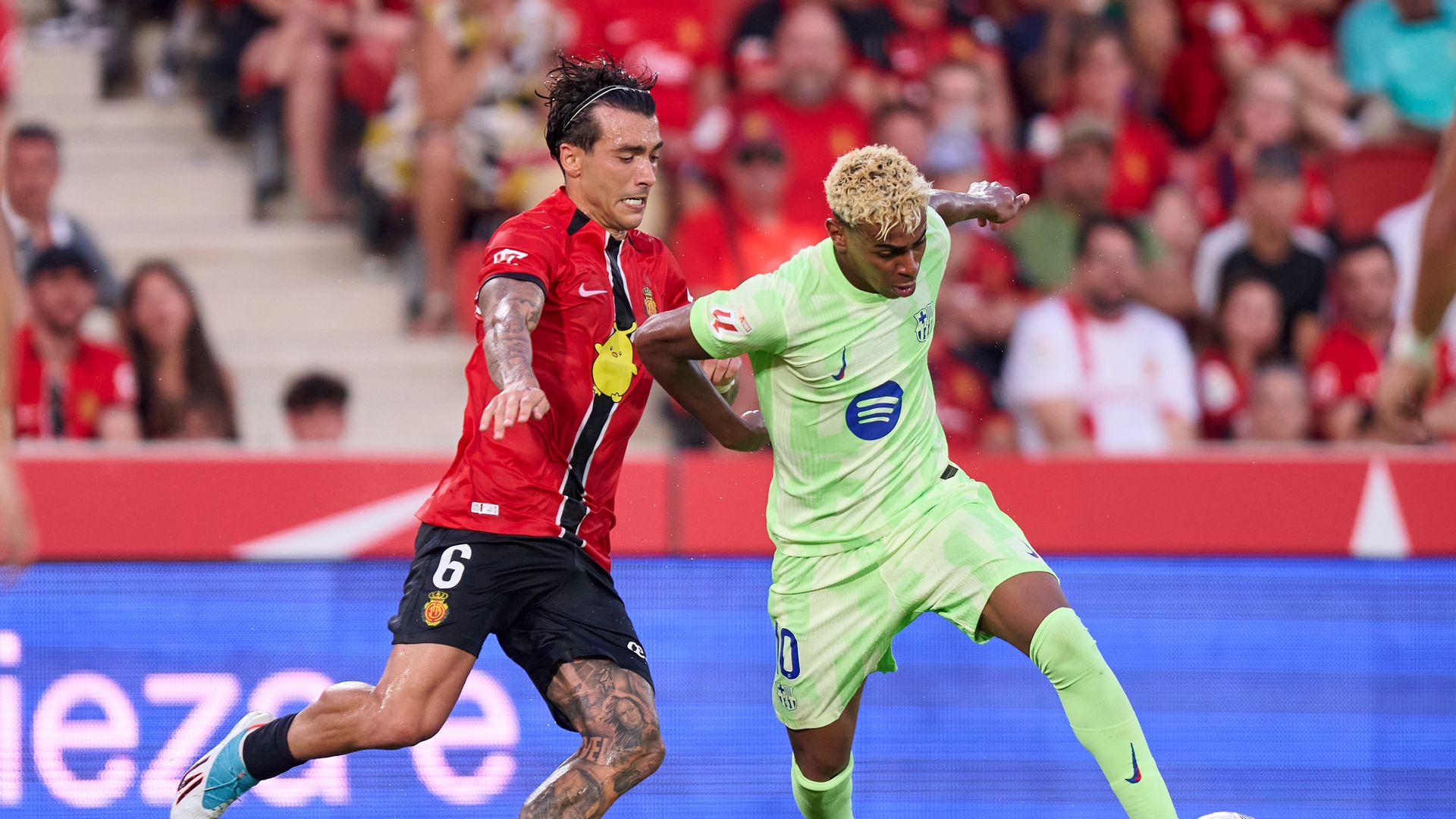 Antonio Sanchez of RCD Mallorca competes for the ball with Lamine Yamal of FC Barcelona during the LaLiga EA Sports match between RCD Mallorca and FC Barcelona 
