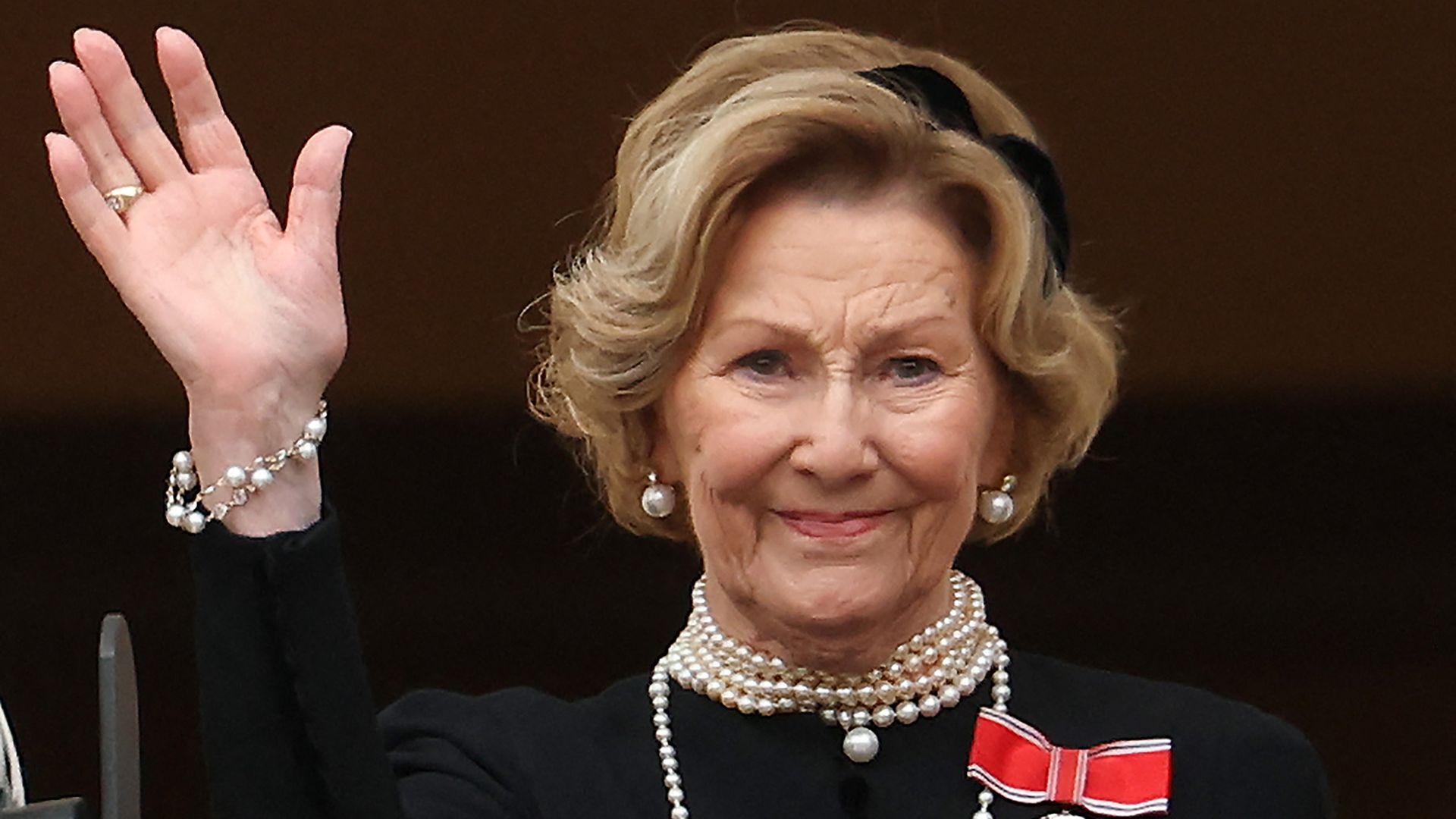 Queen Sonja of Norway waves to the public from the balcony of the Royal Palace in Norway