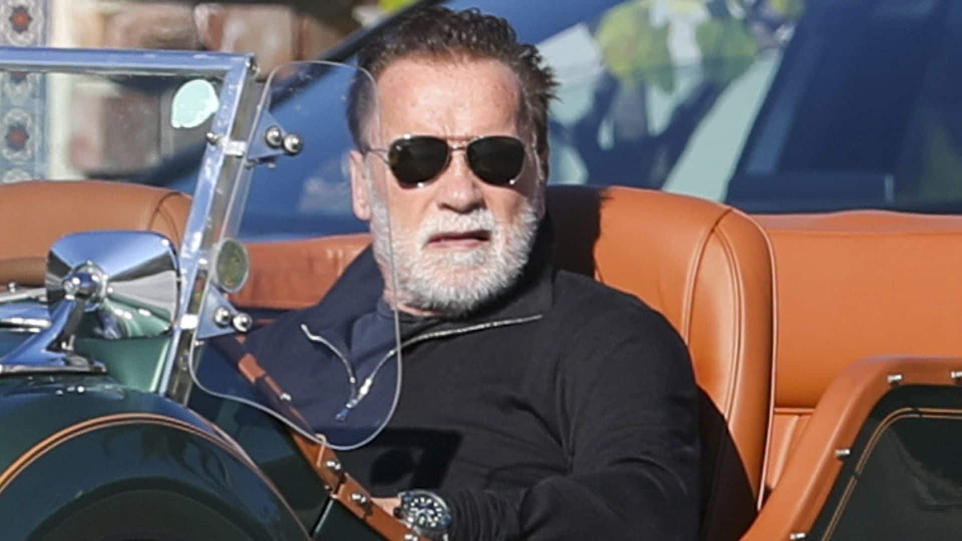 Arnold Schwarzenegger beams while cruising in a classic Mercedes convertible