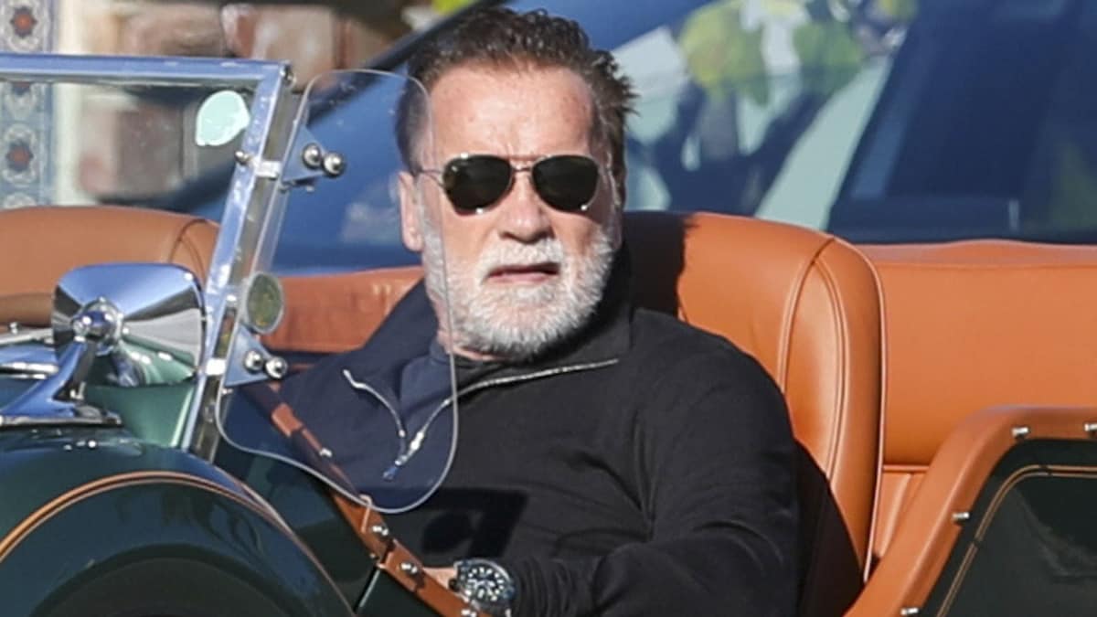 Arnold Schwarzenegger beams while cruising in a classic Mercedes convertible