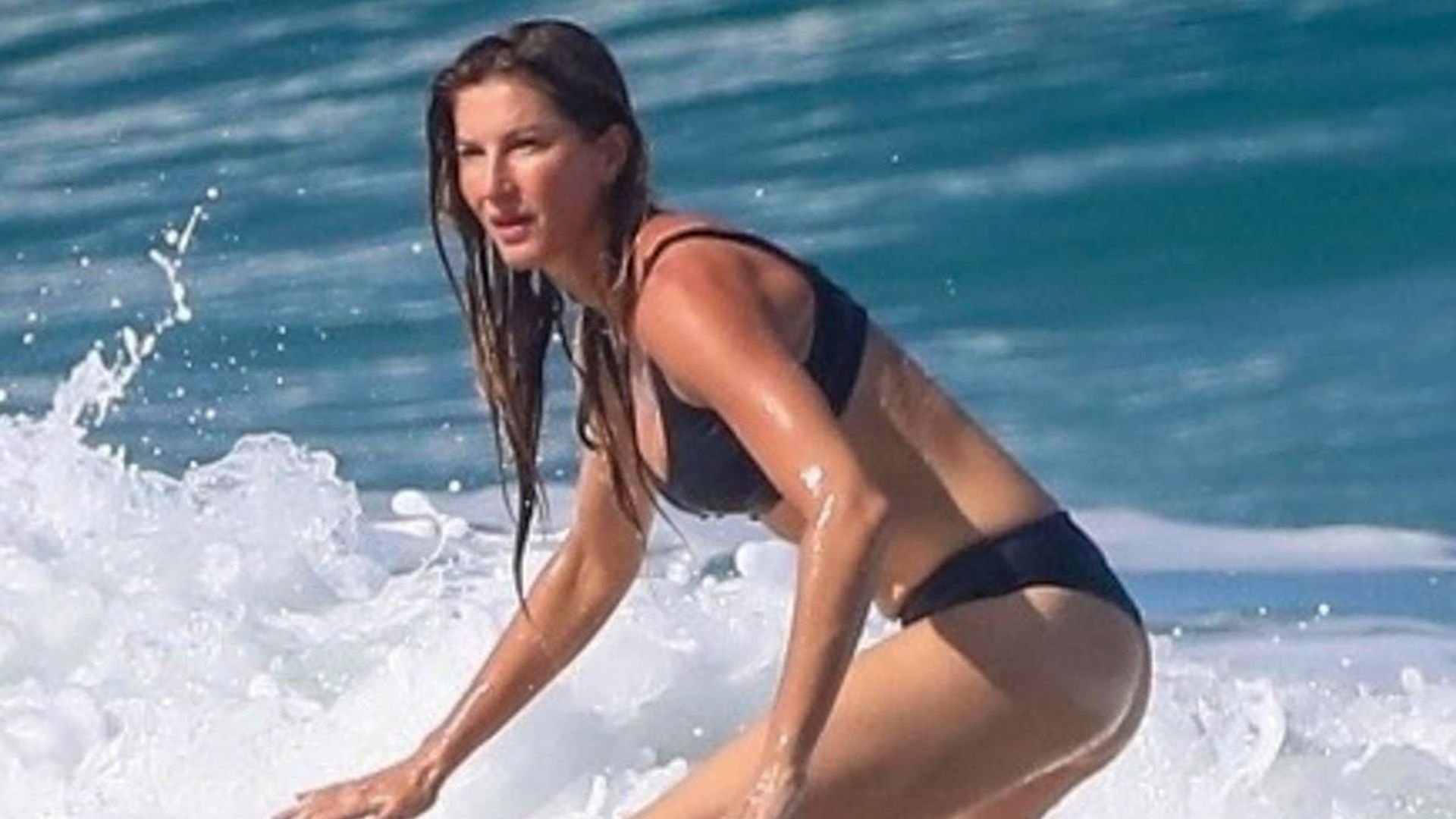 Gisele Bündchen shows off sculpted abs and surfing skills in black bikini