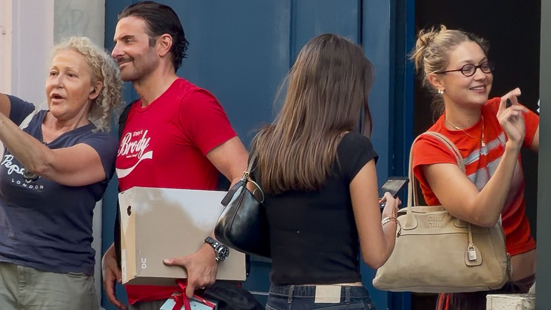 Bradley Cooper and Gigi Hadid wearing coordinated outfits during a stylish daytime outing.