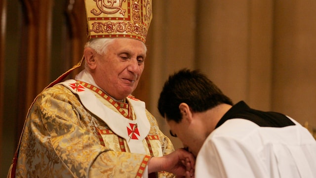 His Holiness Pope Benedict XVI watches as a seminarian kisses his ring during a Holy Mass
