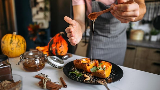 A young man in the rustic kitchen preparing and serving dessert.