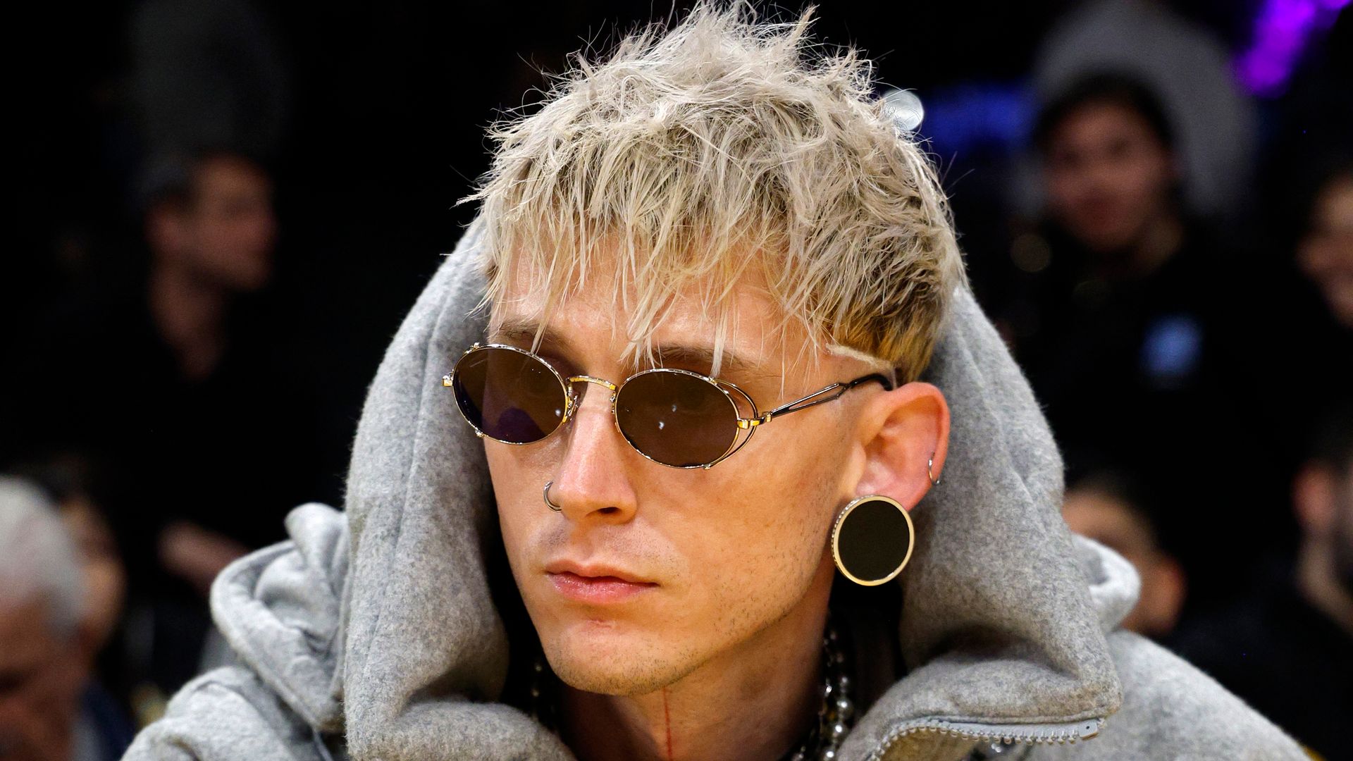 Machine Gun Kelly debuts vampire fangs after blacking out his tattoos