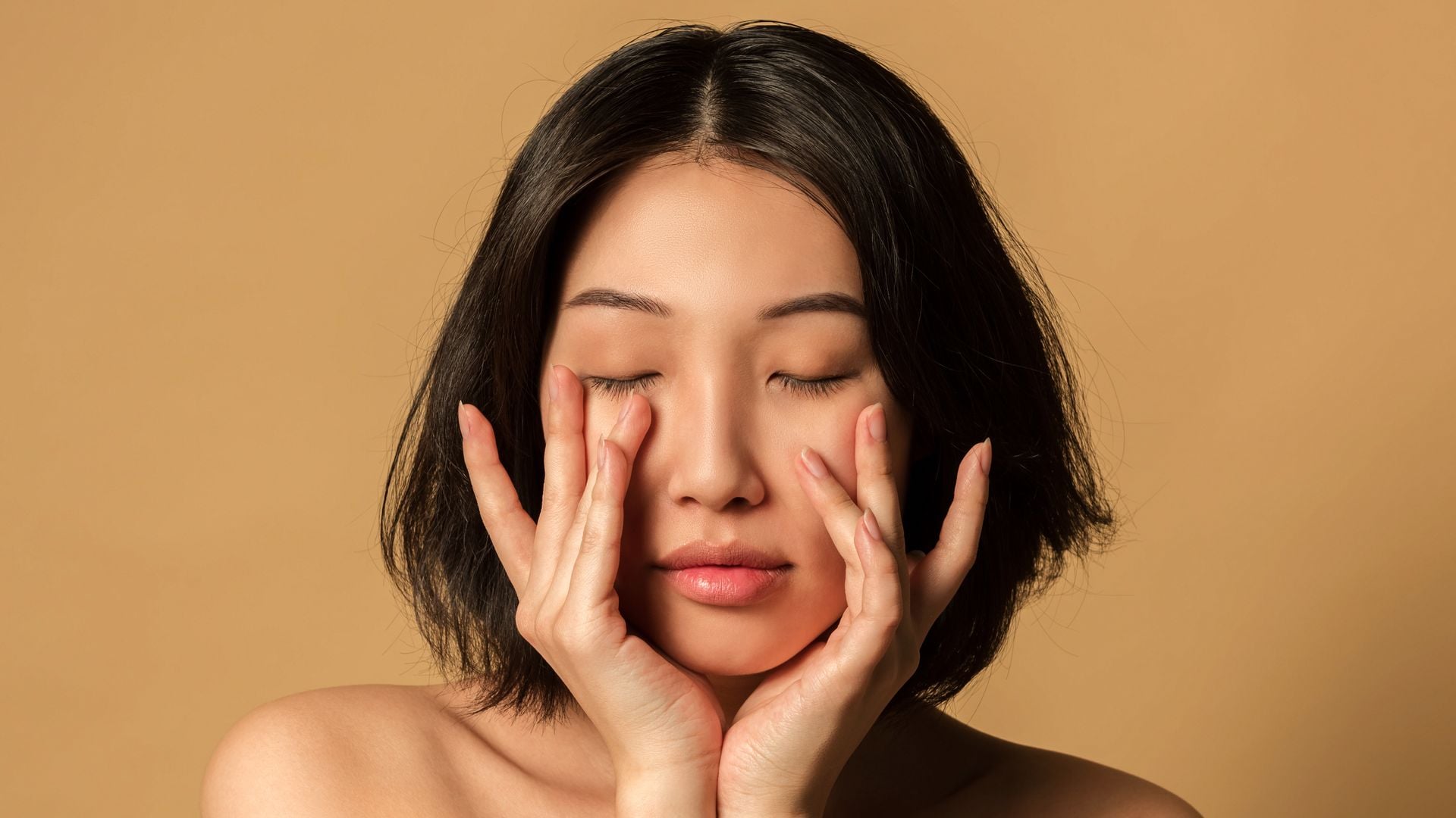 beauty portrait close-up of beautiful woman with clear skin on beige background studio shot