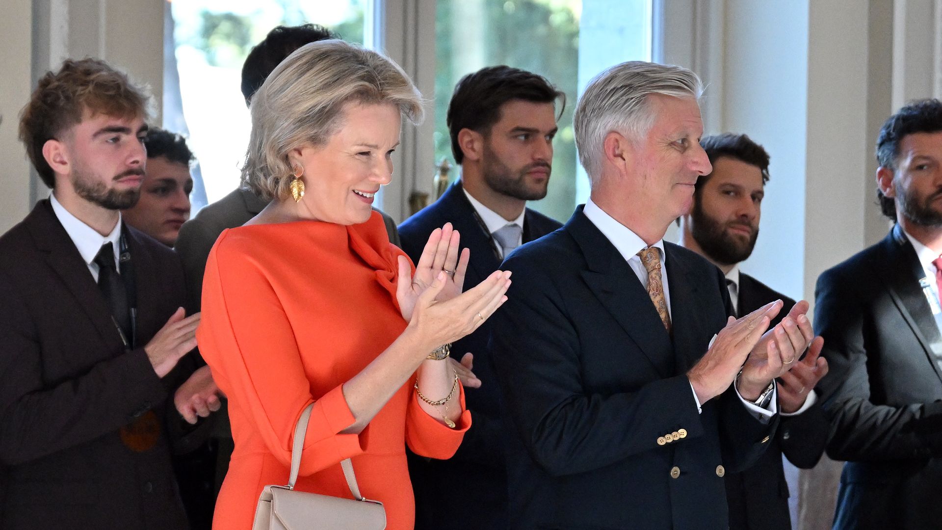 Queen Mathilde brightens up palace reception in an orange dress with a playful twist