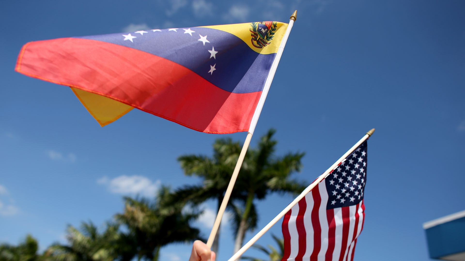 MIAMI, FL - MARCH 01: A protester holds a Venezuelan and American flag as she and other Venezuelans and their supporters show their support for the anti-government protests in Venezuela on March 1, 2014 in Miami, Florida. In Venezuela, protests over the past couple of weeks have resulted in violence as government opponents and supporters have faced off in the streets. (Photo by Joe Raedle/Getty Images)