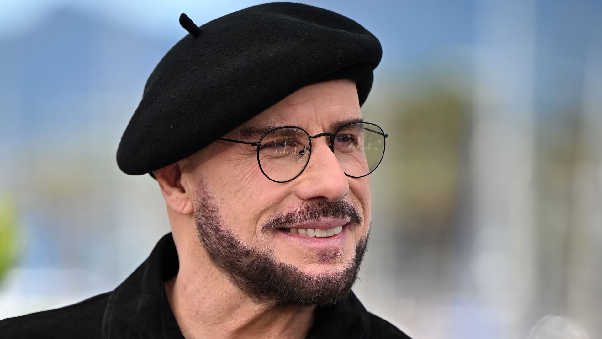 John Travolta pairs his iconic beret with a leather jacket for a Ramones tribute