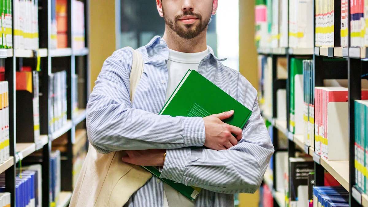 https://www.hola.com/us/horizon/landscape/8a9466a7e37d-confident-young-male-student-holding-books-in-library-aisle.jpg?im=Resize=(1200)