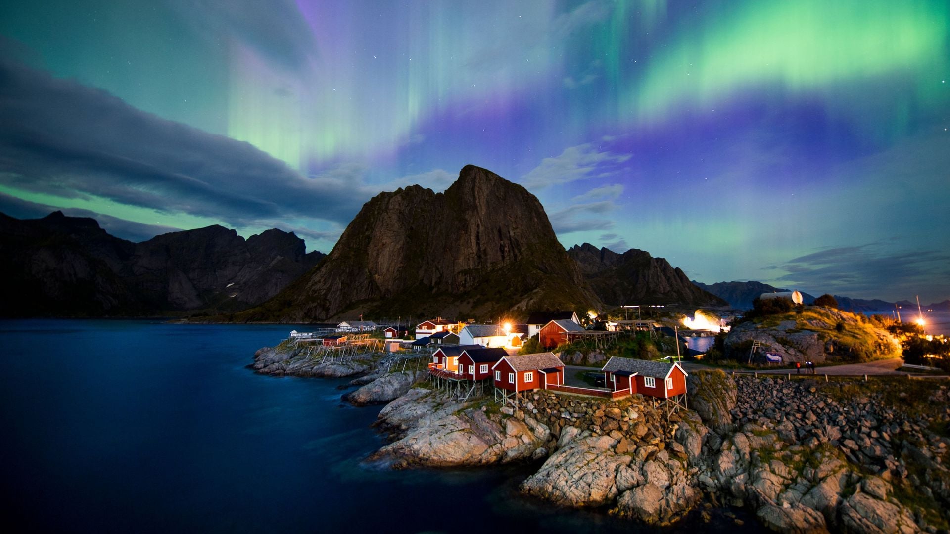 Northern lights (aurora borealis) illuminate the sky over Reinfjorden in Reine, on the Lofoten Islands, Arctic Circle, on September 8, 2017.