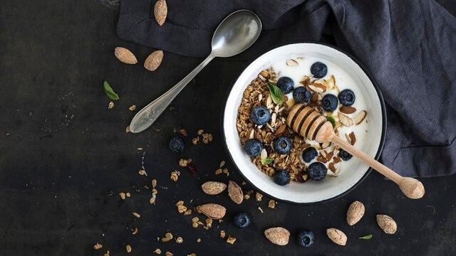 Healthy breakfast - Oat granola with fresh blueberries, almond, yogurt and mint