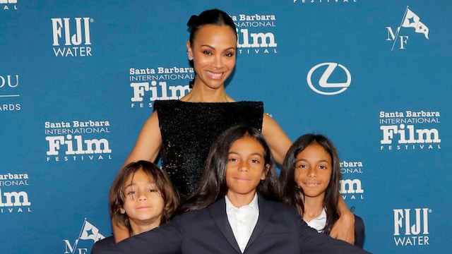 Zoe Saldaña poses with her three sons on the red carpet at the Santa Barbara International Film Festival, all dressed in coordinated navy-blue suits