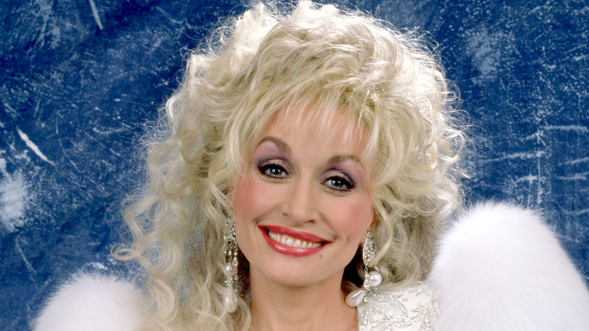 American singer-songwriter, actress, and businesswoman Dolly Parton (1946 - 2026), poses for a studio portrait in Lake Tahoe, California, December 31, 1989. (Photo by Ron Davis/Getty Images)