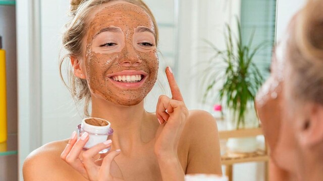 Woman applying an exfoliating mask