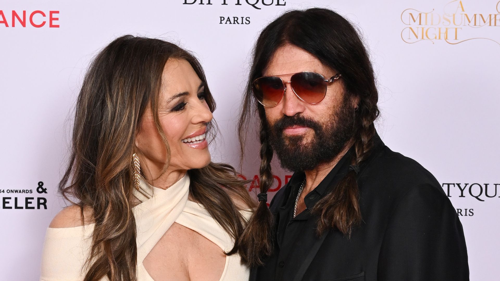 https://www.hola.com/us/horizon/landscape/b952260ad393-london-england-elizabeth-hurley-and-billy-ray-cyrus-attend-the-royal-academy-of-.jpg?im=Resize=(1200)